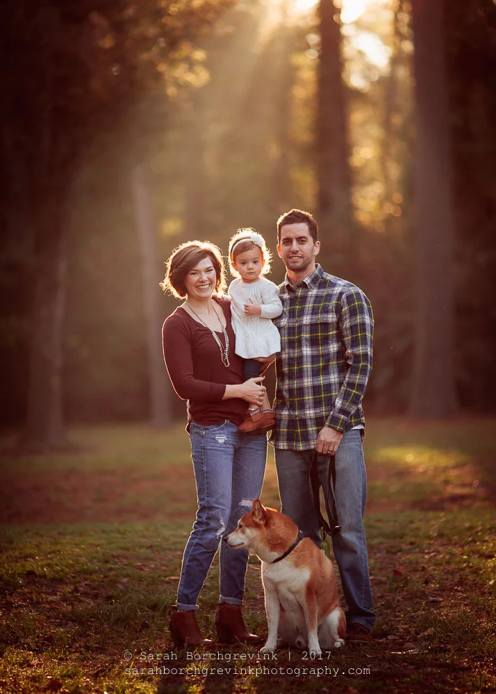 Famille de trois personnes avec leur chien lors d'une séance photo à l'heure dorée