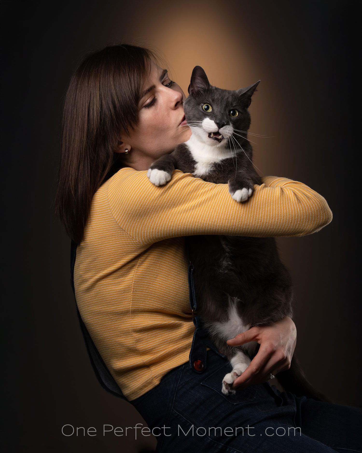 Femme tenant un chat noir et blanc en studio